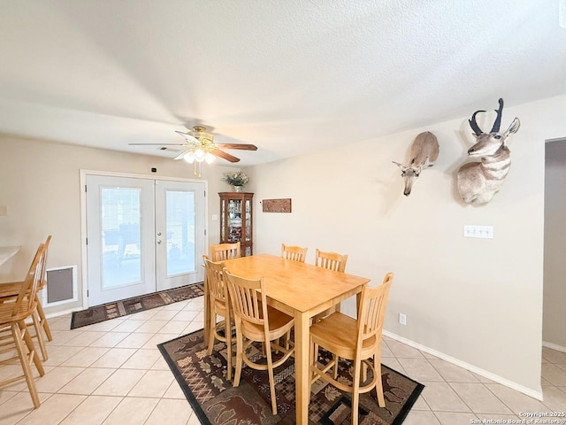 1185 County Road 7718, Devine, TX 78016 - dining space with light tile patterned floors, french doors, ceiling fan, and baseboards