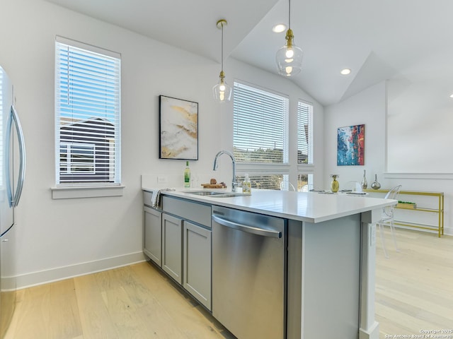 2050 Lohmans Spur Unit, Lakeway, TX 78734 - kitchen featuring appliances with stainless steel finishes, gray cabinets, a sink, a peninsula, and light wood-style floors