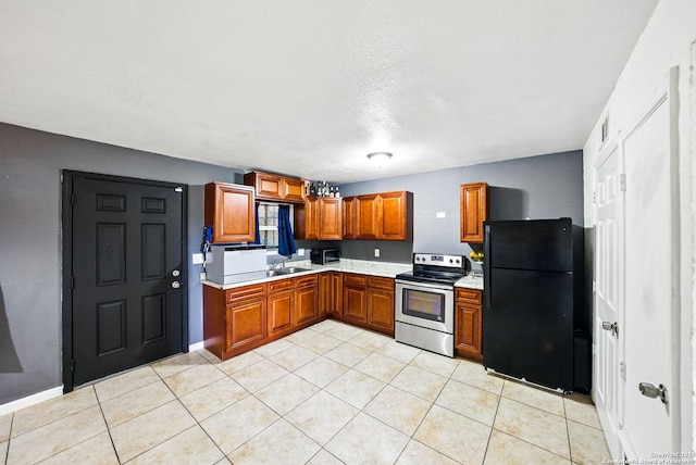 7122 Brecon, San Antonio, TX 78239 - kitchen featuring stainless steel range with electric cooktop, freestanding refrigerator, light countertops, a sink, and brown cabinets