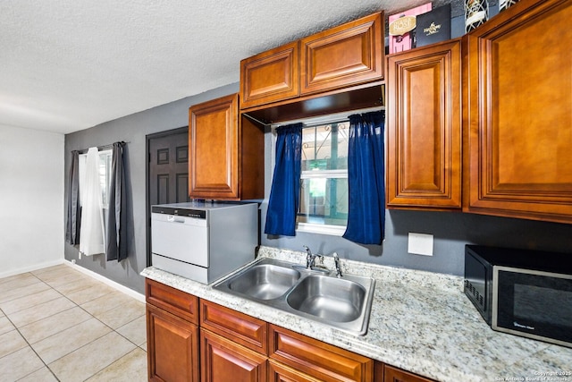 7122 Brecon, San Antonio, TX 78239 - kitchen with a sink, light tile patterned flooring, baseboards, a textured ceiling, and brown cabinets