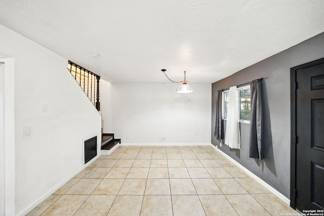 7122 Brecon, San Antonio, TX 78239 - unfurnished living room featuring light tile patterned flooring, baseboards, and stairway