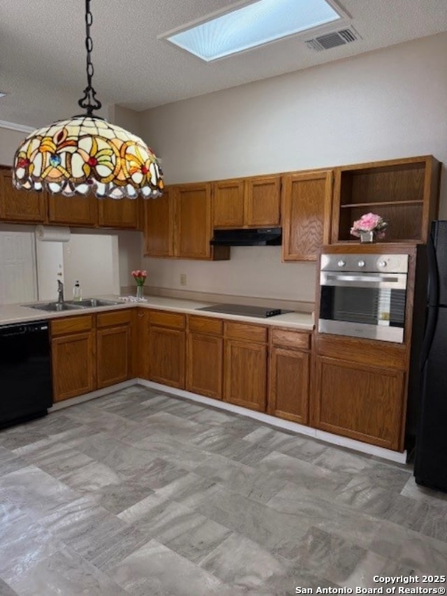 6210 Valley Clf, San Antonio, TX 78250 - kitchen with black appliances, a sink, a skylight, brown cabinetry, and a textured ceiling