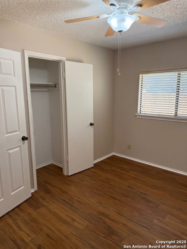 6210 Valley Clf, San Antonio, TX 78250 - unfurnished bedroom featuring wood finished floors, a closet, baseboards, and a textured ceiling