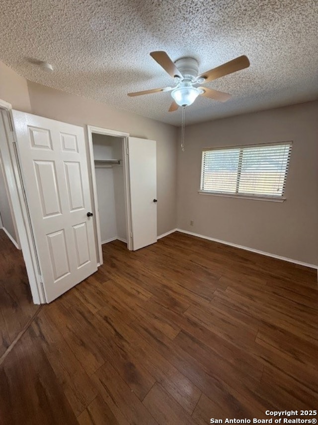 6210 Valley Clf, San Antonio, TX 78250 - unfurnished bedroom with a textured ceiling, dark wood finished floors, baseboards, ceiling fan, and a closet