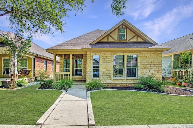 2222 Gruene Lk, New Braunfels, TX 78130 - view of front facade featuring stone siding, a front lawn, roof with shingles, and covered porch