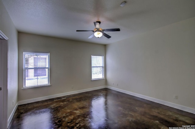 2222 Gruene Lk, New Braunfels, TX 78130 - unfurnished room featuring finished concrete floors, plenty of natural light, a ceiling fan, baseboards, and a textured ceiling