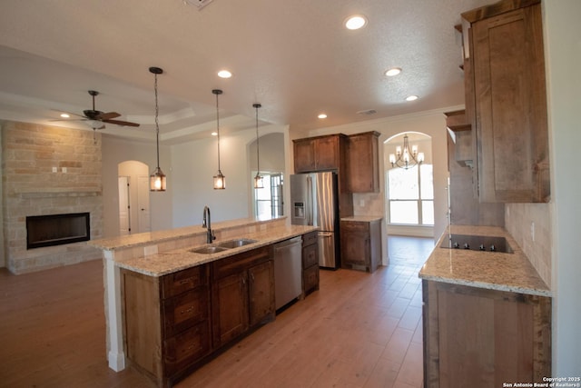 2516 County Road 357, La Vernia, TX 78121 - kitchen with a sink, appliances with stainless steel finishes, ornamental molding, ceiling fan, and a stone fireplace