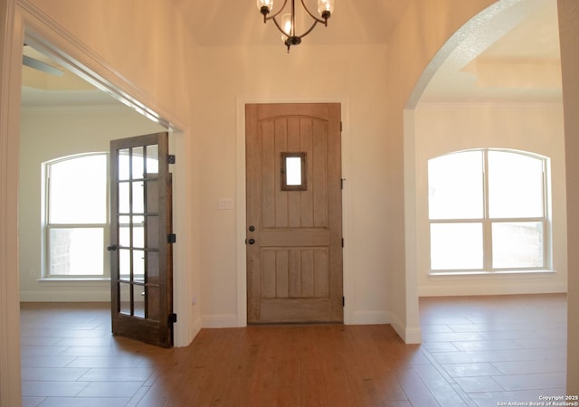 2516 County Road 357, La Vernia, TX 78121 - entrance foyer with arched walkways, a chandelier, plenty of natural light, baseboards, and ornamental molding