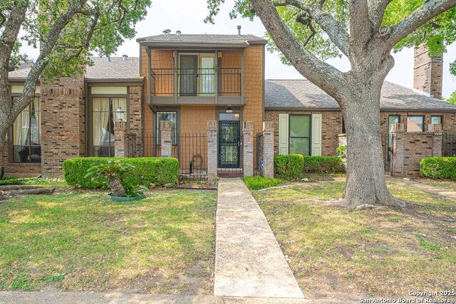 3922 Barrington Unit 0, San Antonio, TX 78217 - view of front of home featuring a front yard, a balcony, brick siding, and roof with shingles