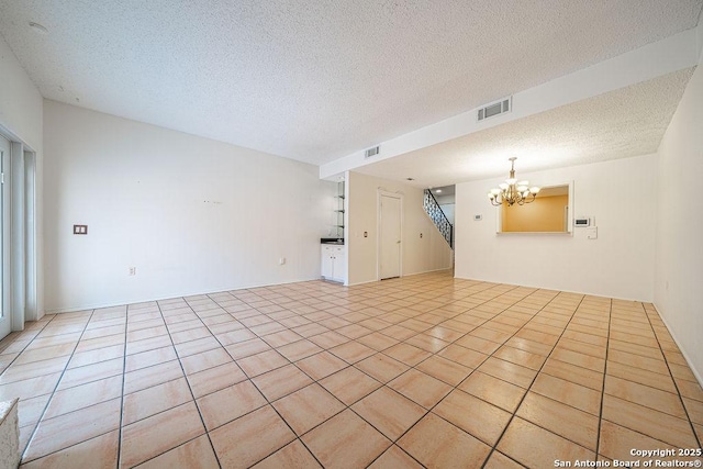 3922 Barrington Unit 0, San Antonio, TX 78217 - unfurnished living room featuring a chandelier, a textured ceiling, and light tile patterned floors