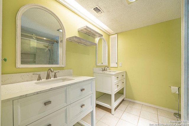 3922 Barrington Unit 0, San Antonio, TX 78217 - full bath with a textured ceiling, two vanities, tile patterned flooring, baseboards, and a shower with door