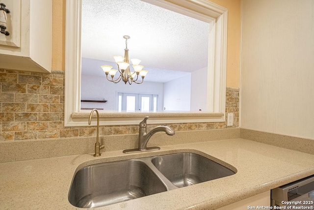 3922 Barrington Unit 0, San Antonio, TX 78217 - kitchen featuring a sink, a chandelier, backsplash, decorative light fixtures, and light stone countertops