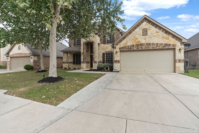 8726 Hideout, San Antonio, TX 78254 - view of front of house with stone siding, driveway, a garage, and a front lawn