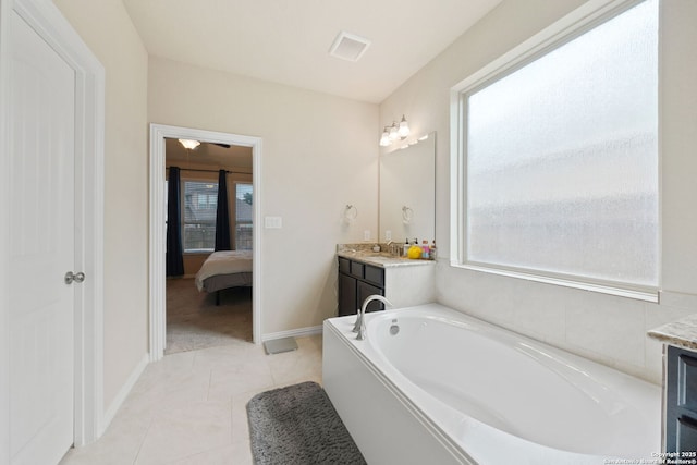 8726 Hideout, San Antonio, TX 78254 - ensuite bathroom featuring vanity, a garden tub, baseboards, and tile patterned flooring