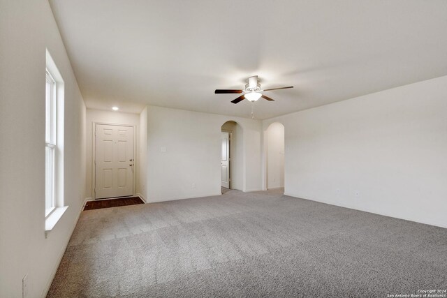 15107 Telfaire Mdw, Von Ormy, TX 78073 - spare room with arched walkways, light colored carpet, and ceiling fan