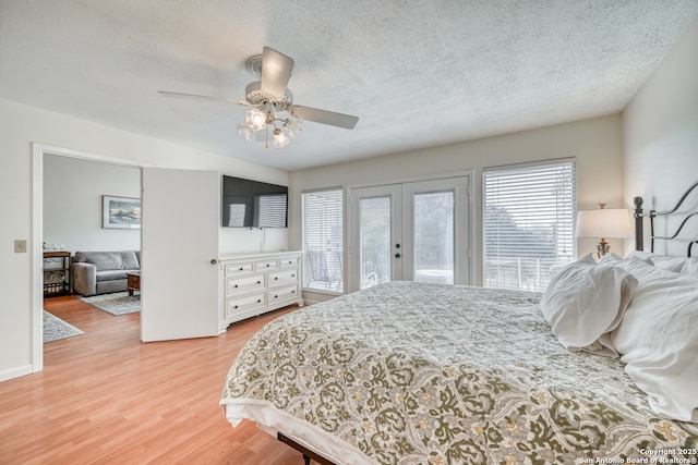 806 Highcrest # 19, Granite Shoals, TX 78654 - bedroom with french doors, multiple windows, access to exterior, a textured ceiling, and light wood-style flooring