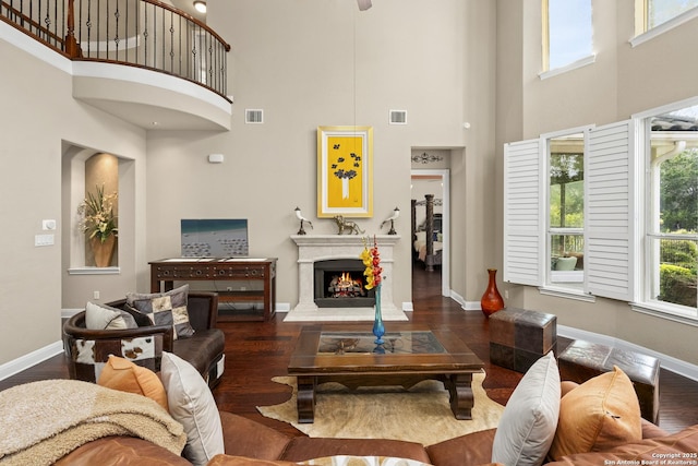 7414 Hovingham, San Antonio, TX 78257 - living room featuring a towering ceiling, wood finished floors, a warm lit fireplace, and baseboards