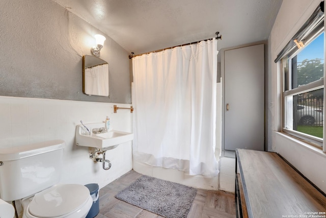 1019 Chicago Blvd, San Antonio, TX 78210 - full bathroom featuring toilet, shower / bath combo with shower curtain, and a wainscoted wall