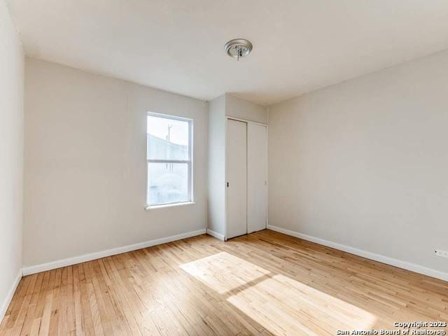 210 Harwood, San Antonio, TX 78213 - unfurnished bedroom featuring hardwood / wood-style floors, baseboards, and a closet