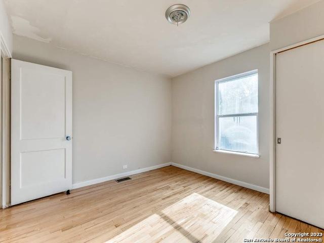 210 Harwood, San Antonio, TX 78213 - unfurnished bedroom featuring light wood finished floors and baseboards
