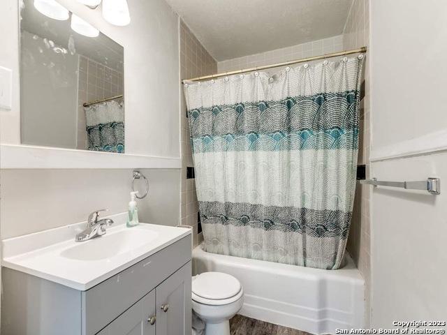 210 Harwood, San Antonio, TX 78213 - full bathroom featuring vanity, shower / bathtub combination with curtain, and toilet