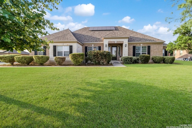 364 Stone Trl, Castroville, TX 78009 - view of front facade with solar panels, a front lawn, brick siding, and roof with shingles