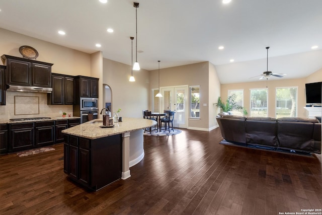 364 Stone Trl, Castroville, TX 78009 - kitchen with appliances with stainless steel finishes, open floor plan, under cabinet range hood, light stone counters, and plenty of natural light