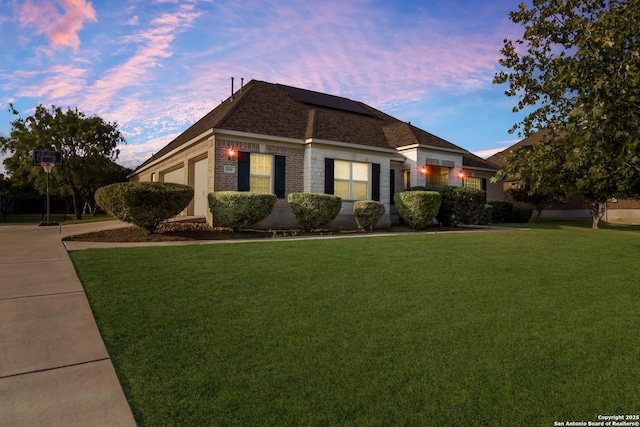 364 Stone Trl, Castroville, TX 78009 - view of front of house featuring a lawn, solar panels, and brick siding