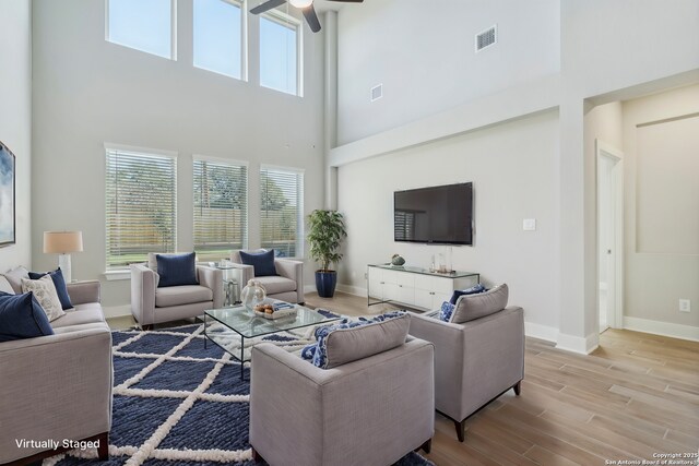 29414 Angelfish Blvd, Boerne, TX 78006 - living area featuring plenty of natural light, a towering ceiling, ceiling fan, wood finished floors, and baseboards