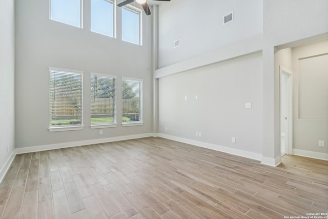 29414 Angelfish Blvd, Boerne, TX 78006 - unfurnished room with plenty of natural light, ceiling fan, a towering ceiling, light wood-style floors, and baseboards