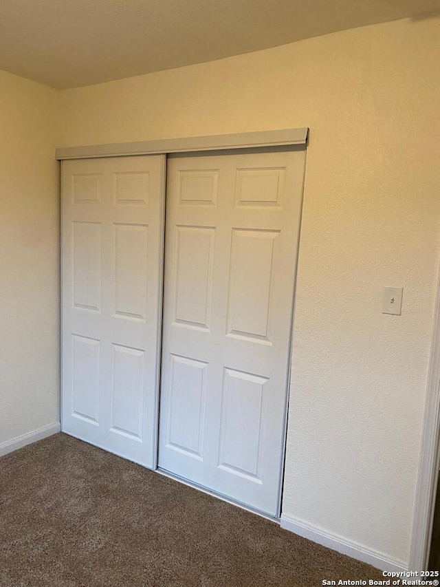 1336 Churing, San Antonio, TX 78245 - unfurnished bedroom featuring dark carpet, a closet, and baseboards