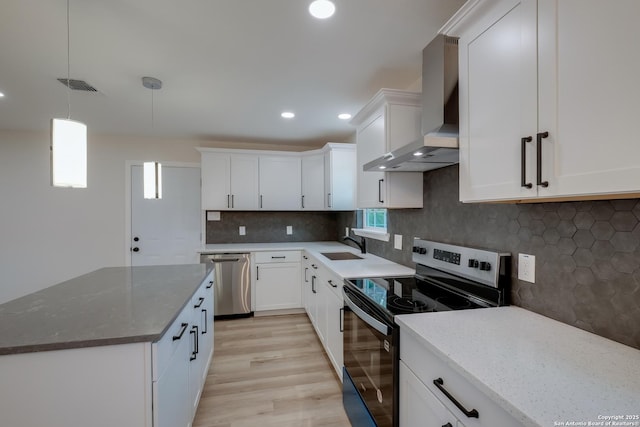 7811 Stagecoach, San Antonio, TX 78227 - kitchen featuring stainless steel appliances, wall chimney range hood, light wood-type flooring, white cabinets, and light stone countertops