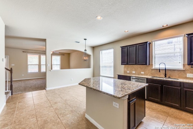 27511 Smokey Chase, Boerne, TX 78015 - kitchen featuring a sink, a kitchen island, backsplash, light stone countertops, and recessed lighting