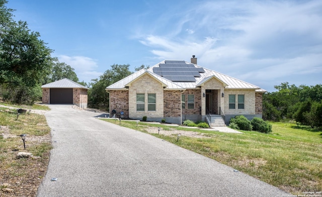 1015 Broken Spoke, Canyon Lake, TX 78133 - ranch-style house with a detached garage, solar panels, an outdoor structure, a chimney, and a standing seam roof