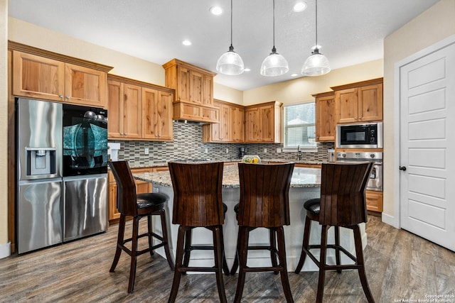 1015 Broken Spoke, Canyon Lake, TX 78133 - kitchen featuring stainless steel appliances, decorative backsplash, dark wood-style floors, a center island, and recessed lighting