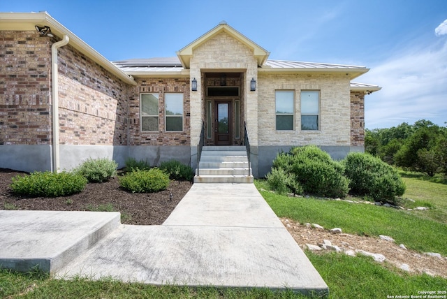 1015 Broken Spoke, Canyon Lake, TX 78133 - doorway to property with a standing seam roof and solar panels