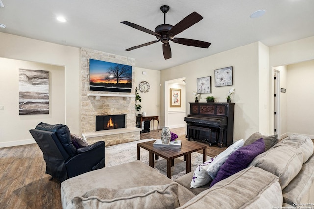 1015 Broken Spoke, Canyon Lake, TX 78133 - living area featuring wood finished floors, baseboards, a ceiling fan, and a stone fireplace