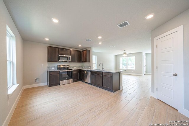 324 Mar Hl, Seguin, TX 78155 - kitchen featuring stainless steel appliances, dark brown cabinetry, baseboards, light wood finished floors, and recessed lighting