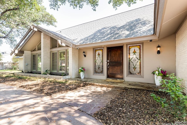 113 Wickford, Castle Hills, TX 78213 - doorway to property with roof with shingles, brick siding, and a patio area