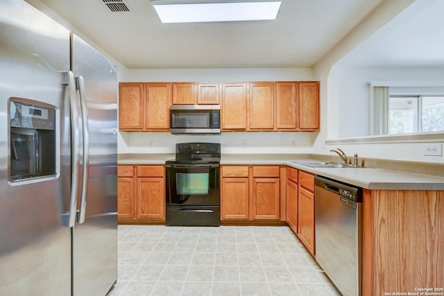 3634 Lazy Clover, San Antonio, TX 78261 - kitchen with stainless steel appliances, a sink, a skylight, light countertops, and a peninsula