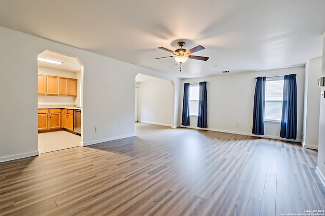 3634 Lazy Clover, San Antonio, TX 78261 - unfurnished living room featuring a ceiling fan, healthy amount of natural light, arched walkways, and light wood-style floors
