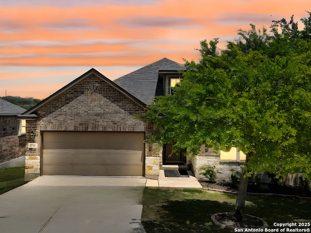 2730 Tortuga Verde, San Antonio, TX 78245 - french country style house with stone siding, driveway, a garage, and brick siding