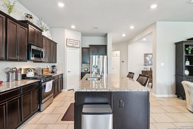 2730 Tortuga Verde, San Antonio, TX 78245 - kitchen with stainless steel appliances, a center island with sink, light stone countertops, a sink, and recessed lighting