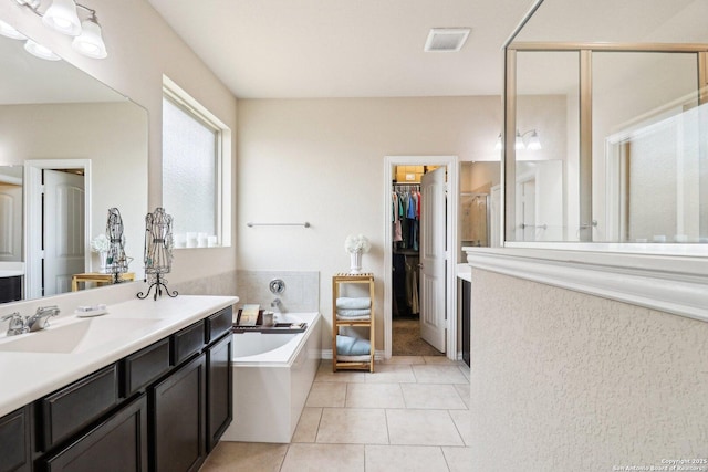 2730 Tortuga Verde, San Antonio, TX 78245 - bathroom featuring vanity, a bath, tile patterned floors, a spacious closet, and a shower stall