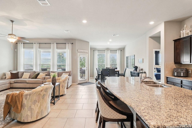 2730 Tortuga Verde, San Antonio, TX 78245 - kitchen featuring open floor plan, a sink, light stone counters, recessed lighting, and light tile patterned flooring