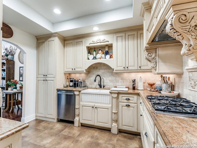3318 Stone Cave, San Antonio, TX 78247 - kitchen with appliances with stainless steel finishes, a sink, arched walkways, cream cabinetry, and backsplash
