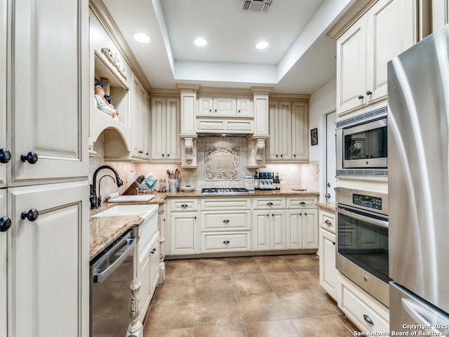 3318 Stone Cave, San Antonio, TX 78247 - kitchen featuring appliances with stainless steel finishes, backsplash, a sink, light stone countertops, and recessed lighting