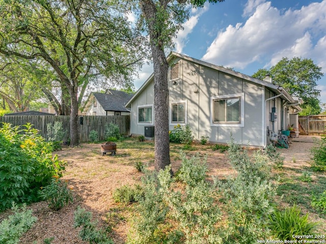 3318 Stone Cave, San Antonio, TX 78247 - back of house with a fire pit, a fenced backyard, central AC, and a chimney