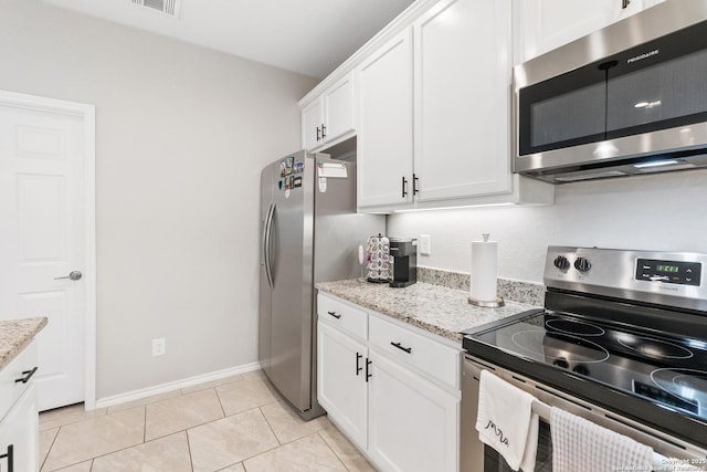 422 42nd, San Antonio, TX 78237 - kitchen featuring appliances with stainless steel finishes, white cabinetry, light stone counters, and light tile patterned floors