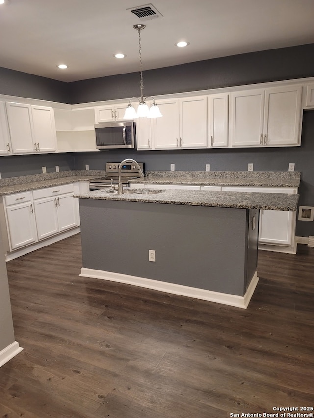 1038 W Ridgewood Ct, San Antonio, TX 78201 - kitchen featuring stainless steel microwave, white cabinetry, pendant lighting, an island with sink, and light stone counters